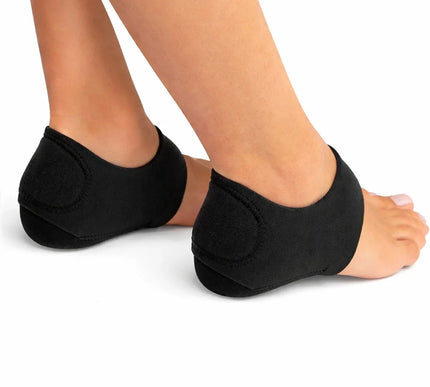 Pair of feet wearing black cushioned heel sleeves for foot support on white background
